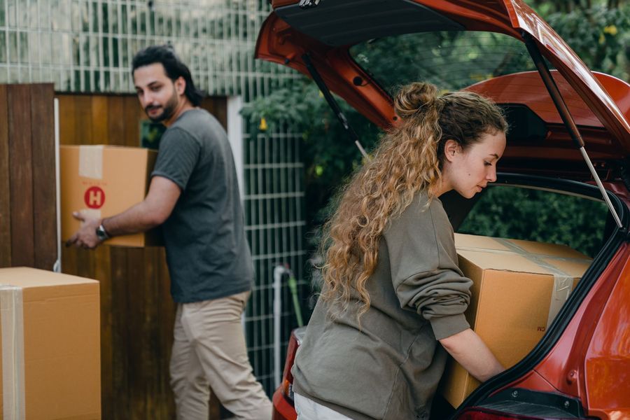 Boxes being unloaded from a vehicle on a house move