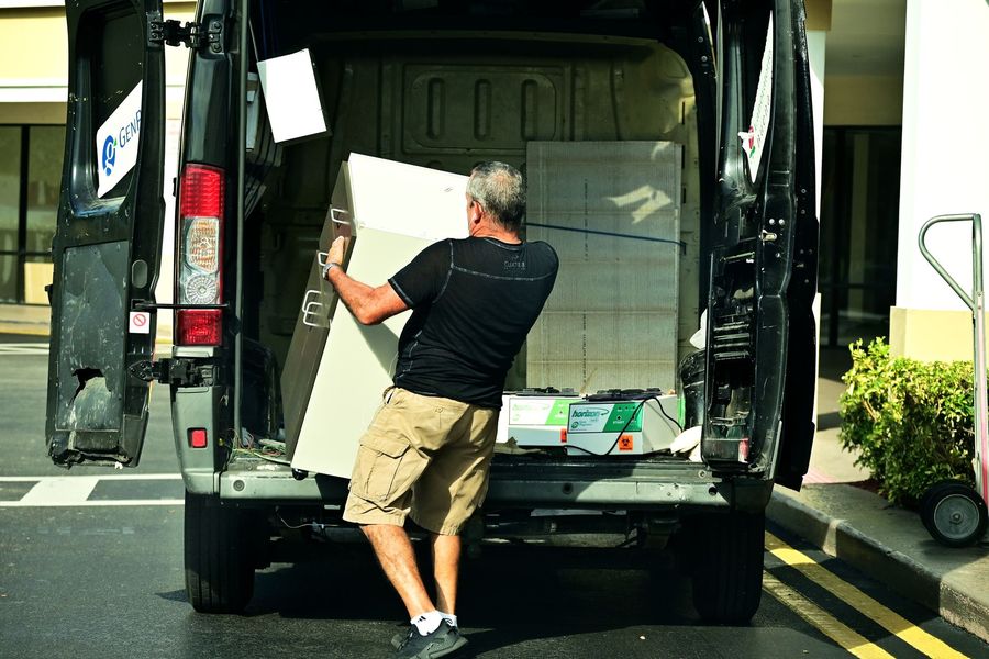 A man loading furniture into an open van