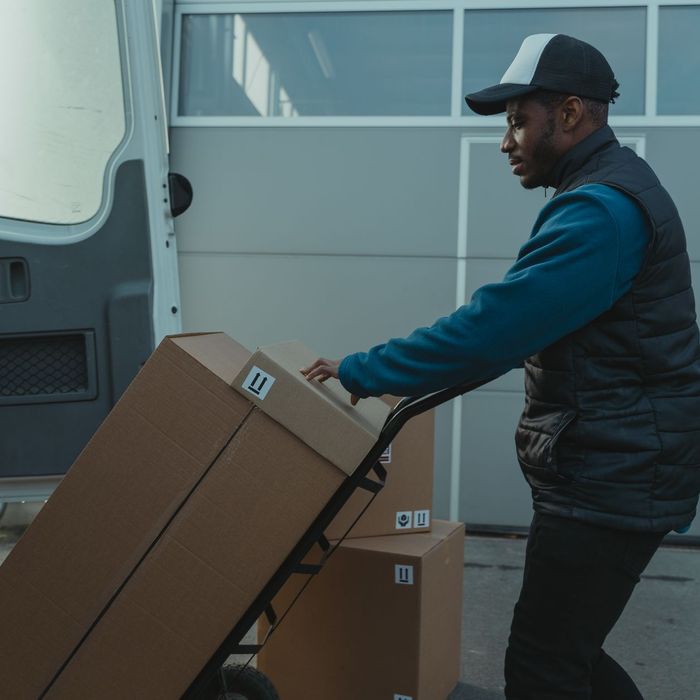 A mover wheeling a stack of boxes on a trolley